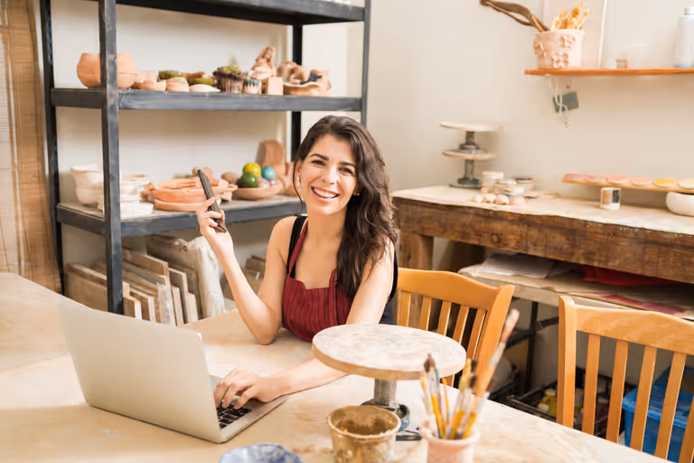 Artist working in her studio with Art Easely open on a laptop